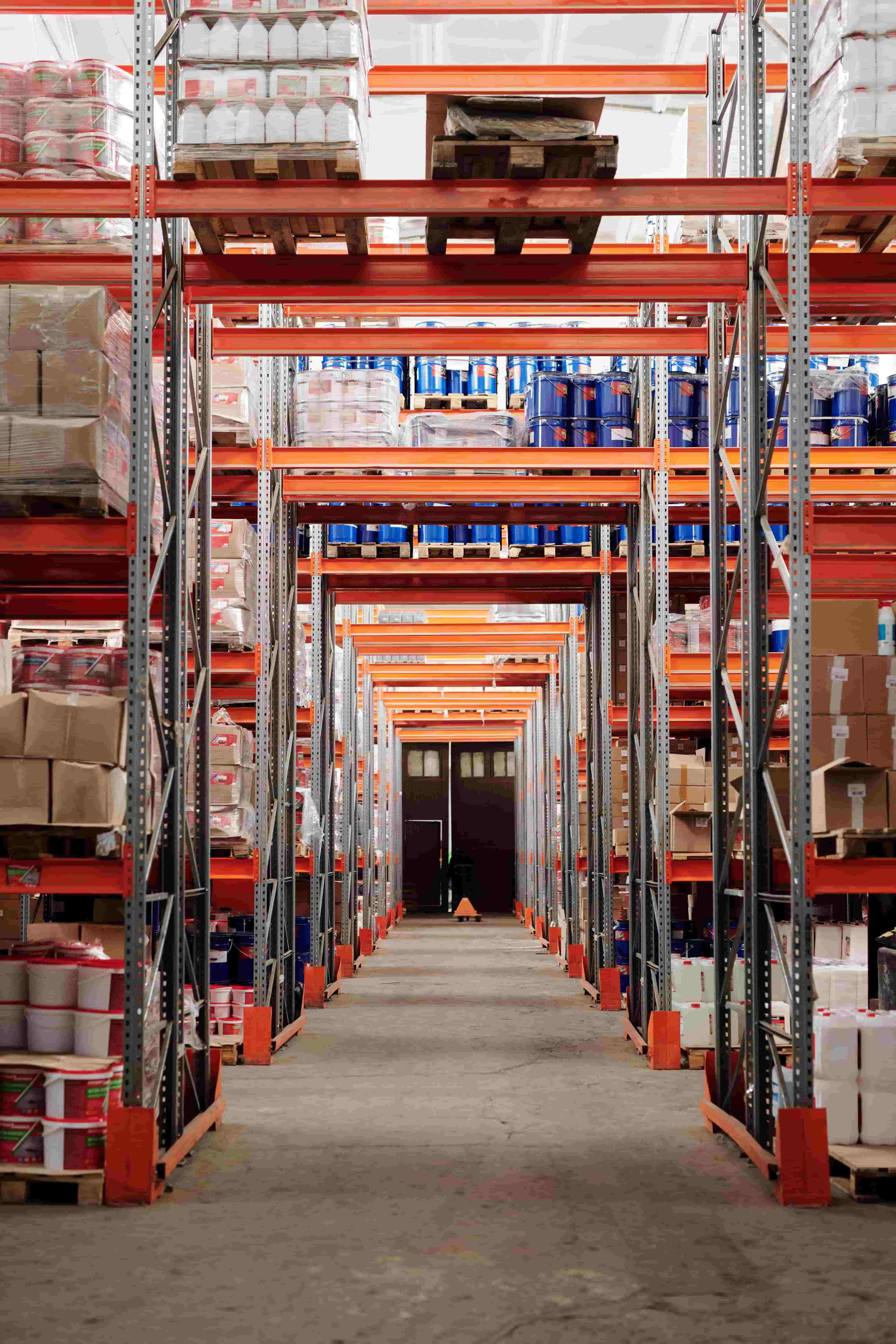 Automated warehouse aisle where pallets move efficiently but records can drift from reality